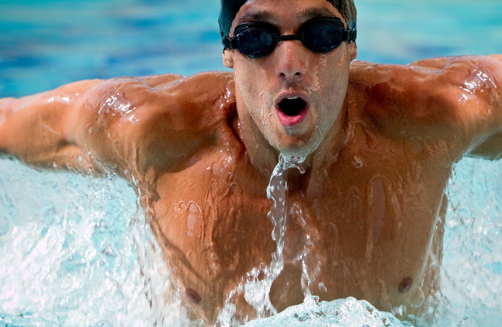 Professional man swimming with hat and goggles at the pool