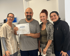 HMS staff with patient and family holding certificate of completion up
