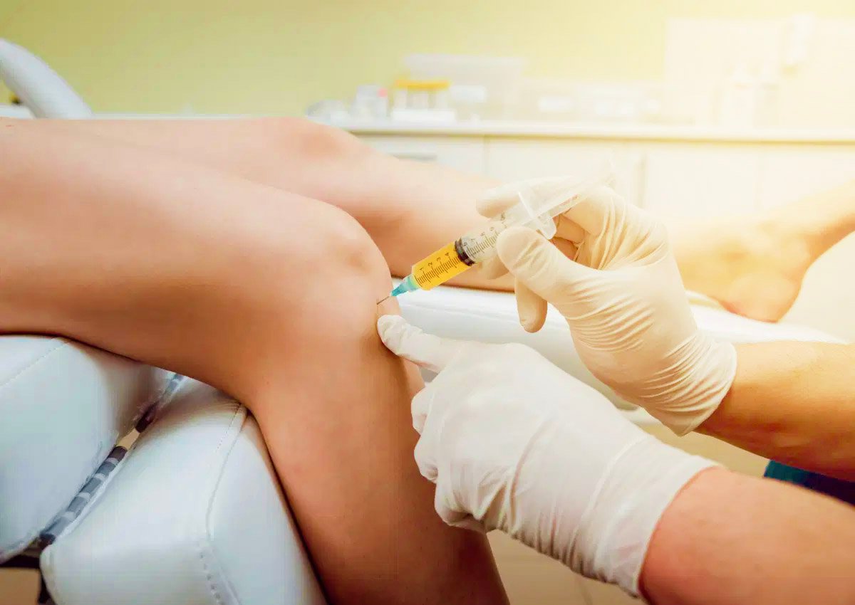 Doctor injecting PRP into a woman's knee