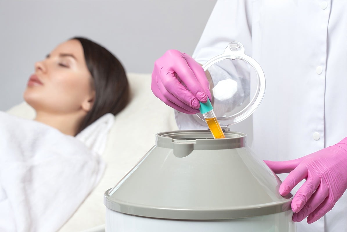woman laying on cot as doctor uses centrifuge to prepare prp therapy solution
