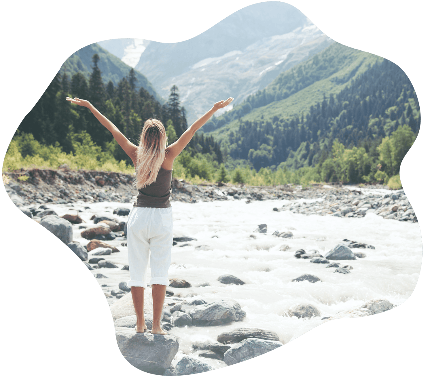 Woman with her arms out against a mountain and river landscape